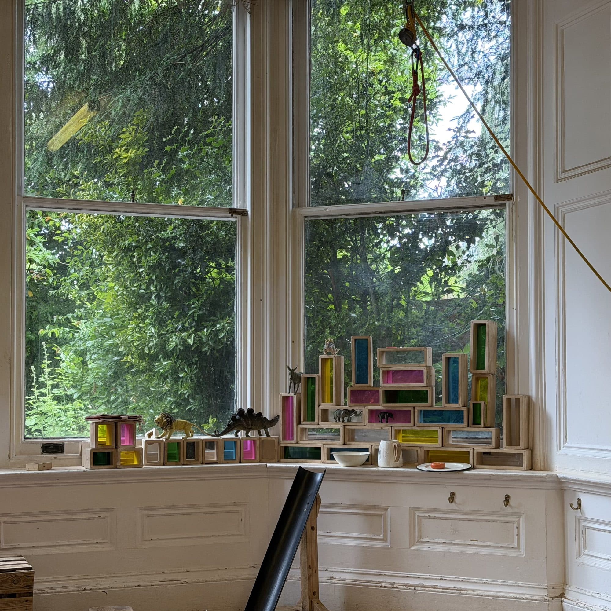 Tall bay windows and rainbow blocks in a playroom at The Manor House Nursery, Westbury on Trym
