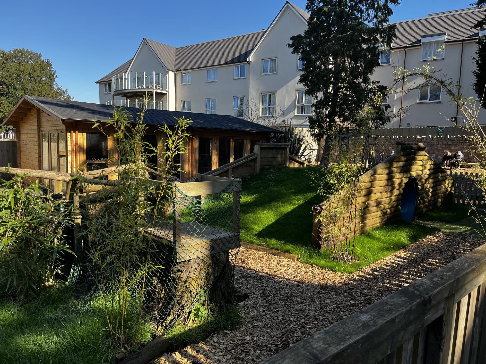 The garden cabin, lawn and log tunnel at The Manor House Nursery, Westbury on Trym