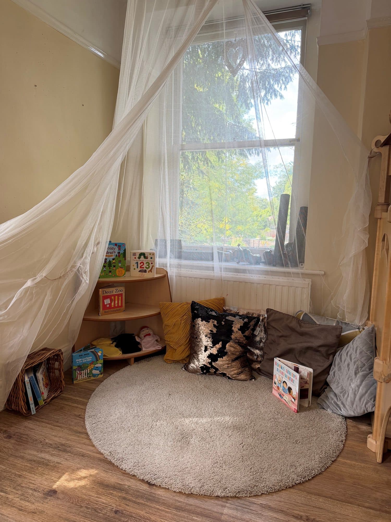 A cosy reading nook with cushions and books at The Manor House Nursery, Westbury on Trym